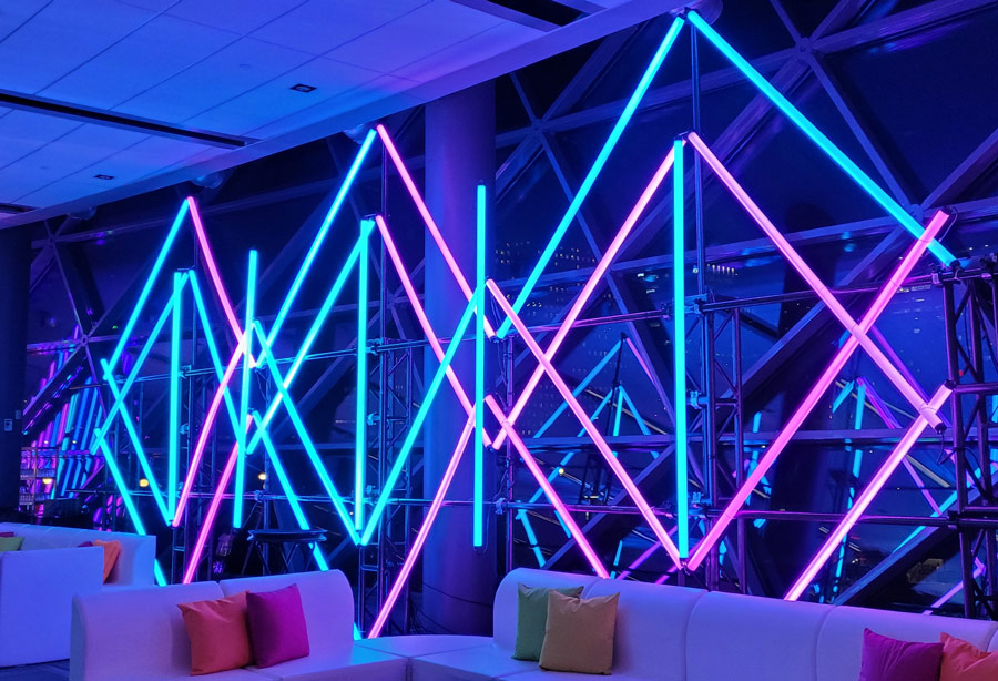 Modern neon lighting in a blue and white diamond pattern lights up a night-time space at the Ottawa Shaw Centre.