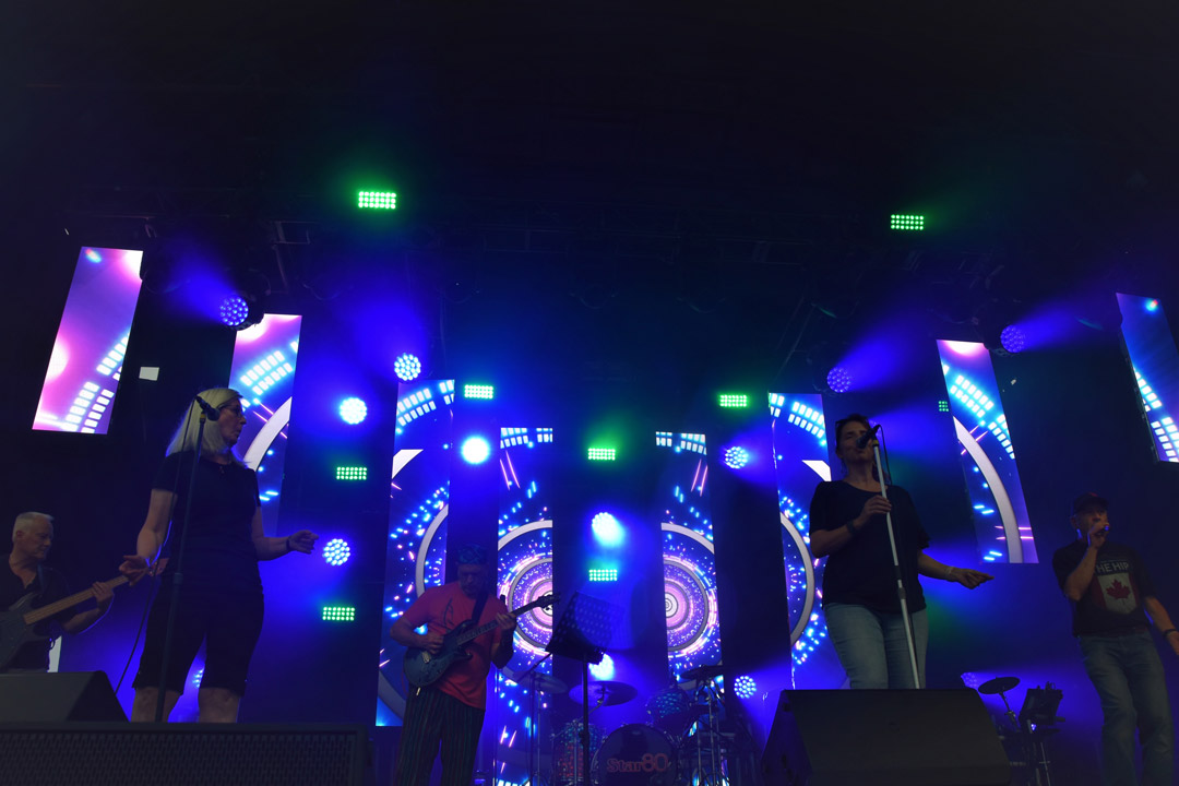 Performers in front of a blue LED screen