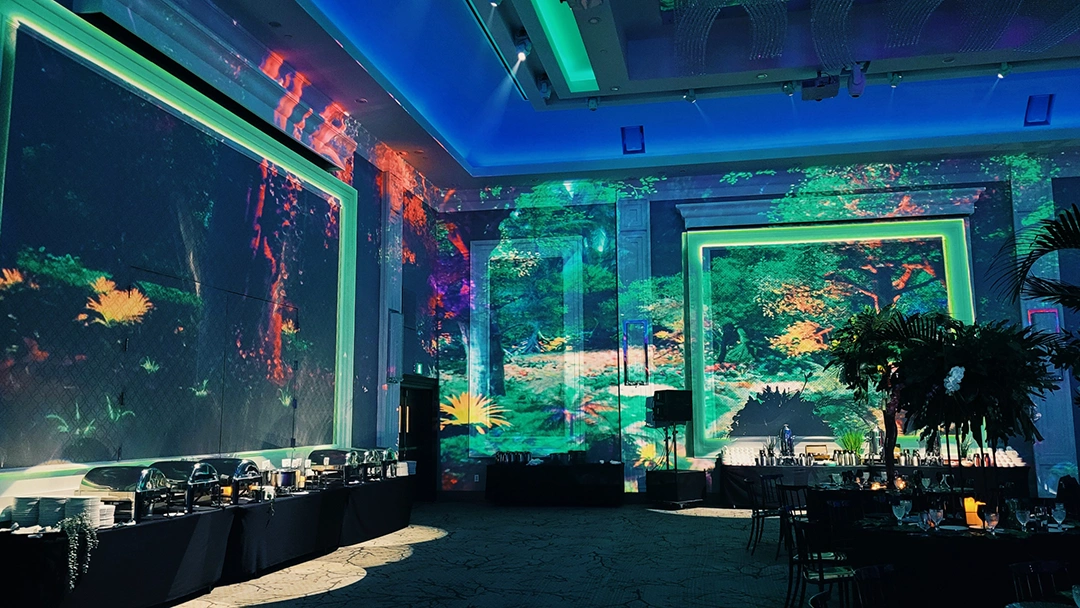 A beautiful jungle image is projected onto the walls of a dimly lit conference centre dining room at the Caivan Gala