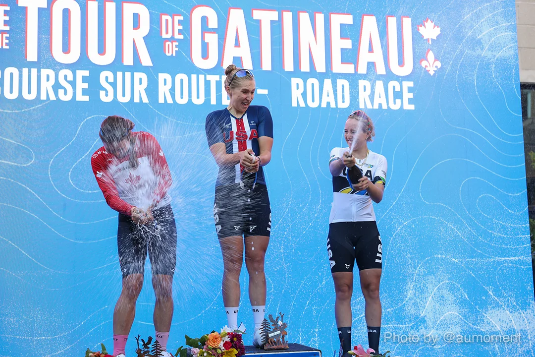 Tour de Gatineau winners pop champaign and celebrate in front of a large video wall with the Tour de Gatineau logo