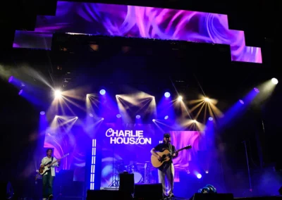 OSE Event Portfolio Photos - Capital Pride stage with blue and purple swirls displayed on the video wall behind the performer Chrlie Houston