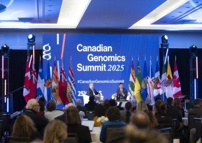 OSE Event Portfolio Photos - Genome Summit blue backdrop with Canadian Genomics Summit 2025 and two speakers sitting in front of an audience.