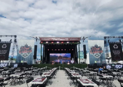 OSE Event Portfolio Photos - Great Outdoors Comedy Festival Stage with video walls. Empty table and chairs in front